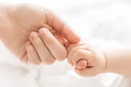 Baby greift nach Hand